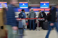 Travelers wait in line at Detroit Metropolitan Wayne County Airport Sunday, Nov. 30, 2025, in Romulus, Mich. (AP Photo/Ryan Sun)