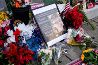Flowers, challenge coins and other items lay near a photograph of U.S. Army Spc. Sarah Beckstrom at a makeshift memorial outside of Farragut West Station, near the site where two National Guard members were shot, Monday, Dec. 1, 2025, in Washington. (AP Photo/Julia Demaree Nikhinson)