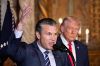 Defense Secretary Pete Hegseth speaks as President Donald Trump looks on, at Trump's Mar-a-Lago club, Monday, Dec. 22, 2025, in Palm Beach, Fla. (AP Photo/Alex Brandon)