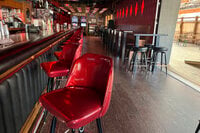 Stools line the bar at Elwood's Liquor and Tap on Thursday, July 18, 2024 in Milwaukee, Wis. This week's Republican National Convention didn't deliver an overwhelming victory to some small businesses in downtown Milwaukee. There had been earlier promises of an economic boost, but some bars, convenience stores and restaurants along the edge of the secure zone sat largely empty all week. (AP Photo/Patrick Orsagos)