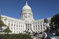 FILE - A man walks by the Wisconsin state Capitol, Oct. 10, 2012, in Madison, Wis. (AP Photo/Scott Bauer, File)