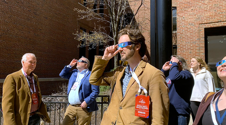 Matthew DeFour, Wisconsin Watch’s statehouse bureau chief, watches the April 8, 2024, eclipse outside the Miller High Life Theatre in downtown Milwaukee. (Jack Kelly / Wisconsin Watch)