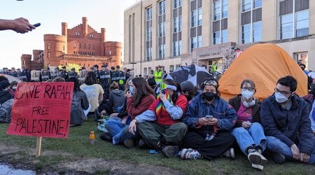 UW-Madison protesters sit around tents at 8:40 a.m. as police work to dismantle their encampment on Library Mall. (Baylor Spears | Wisconsin Examiner)