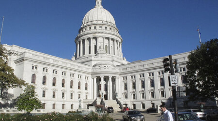 FILE - A man walks by the Wisconsin state Capitol, Oct. 10, 2012, in Madison, Wis. (AP Photo/Scott Bauer, File)