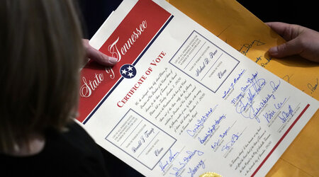 FILE - Staff members hold the certification of Electoral College votes from Tennessee during a joint session of the House and Senate to confirm Electoral College votes at the Capitol, early Jan 7, 2021, in Washington. (AP Photo/Andrew Harnik, File)