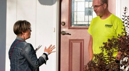 Kathy Moran, left, canvases houses Wednesday, Oct. 23, 2024, in Cross Plains, Wis. (AP Photo/Morry Gash)