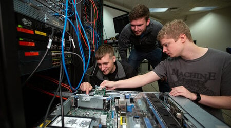 UW-Stout students work on a computer server in a lab.