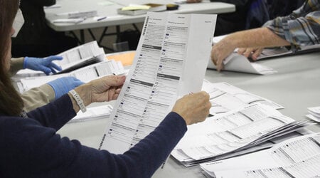 FILE - An election worker examines a ballot at the Clackamas County Elections office, May 19, 2022, in Oregon City, Ore. Problems with a ballot-sorting machine are delaying the vote count in a suburban Portland, Oregon county where issues with blurry bar codes on mail-in ballots delayed elections results in a key Congressional primary race for two weeks in 2022. (AP Photo/Gillian Flaccus, File)