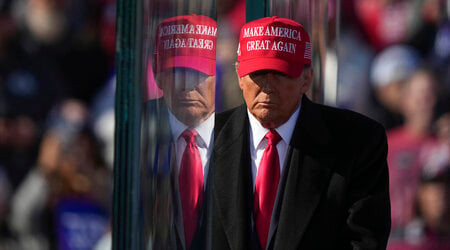 Republican presidential nominee former President Donald Trump is reflected in the bullet proof glass as he finishes speaking at a campaign rally in Lititz, Pa., Sunday, Nov. 3, 2024. (AP Photo/Matt Rourke)