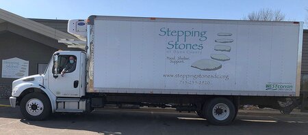 Executive Director Padraig Gallagher takes the wheel of the recently purchased 2014 Freightliner now emblazoned with Stepping Stones of Dunn County’s distinctive logo.