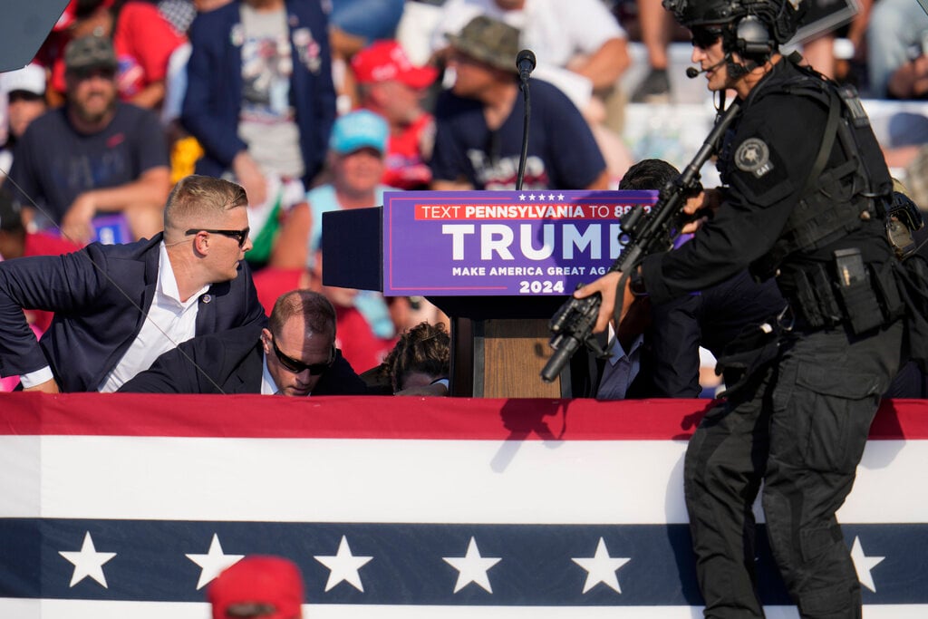 Republican presidential candidate former President Donald Trump is surrounded by U.S. Secret Service at a campaign event in Butler, Pa., on Saturday, July 13, 2024. (AP Photo/Gene J. Puskar)