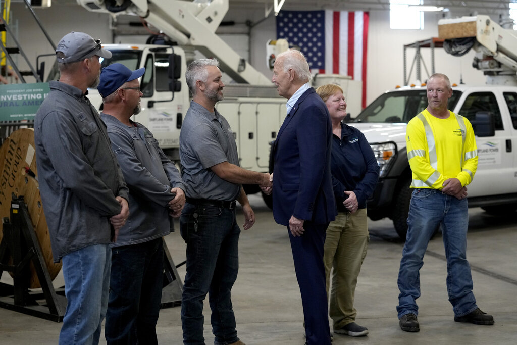 President Joe Biden, third from right, greets workers from Dairyland Power Cooperative and Vernon Electric Cooperative during a visit to Vernon Electric in Westby, Wis., Thursday, Sept. 5, 2024. Biden is in Wisconsin to promote his Investing in America agenda. (AP Photo/Susan Walsh)