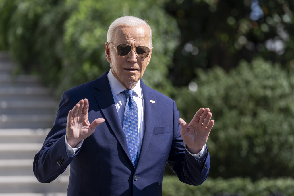 President Joe Biden gestures to the media as he walks to Marine One on the South Lawn of the White House in Washington, Saturday, Oct. 5, 2024. (AP Photo/Ben Curtis)