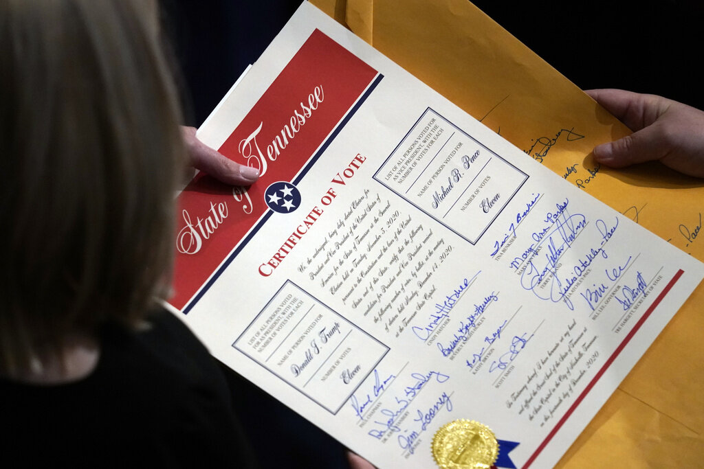 FILE - Staff members hold the certification of Electoral College votes from Tennessee during a joint session of the House and Senate to confirm Electoral College votes at the Capitol, early Jan 7, 2021, in Washington. (AP Photo/Andrew Harnik, File)