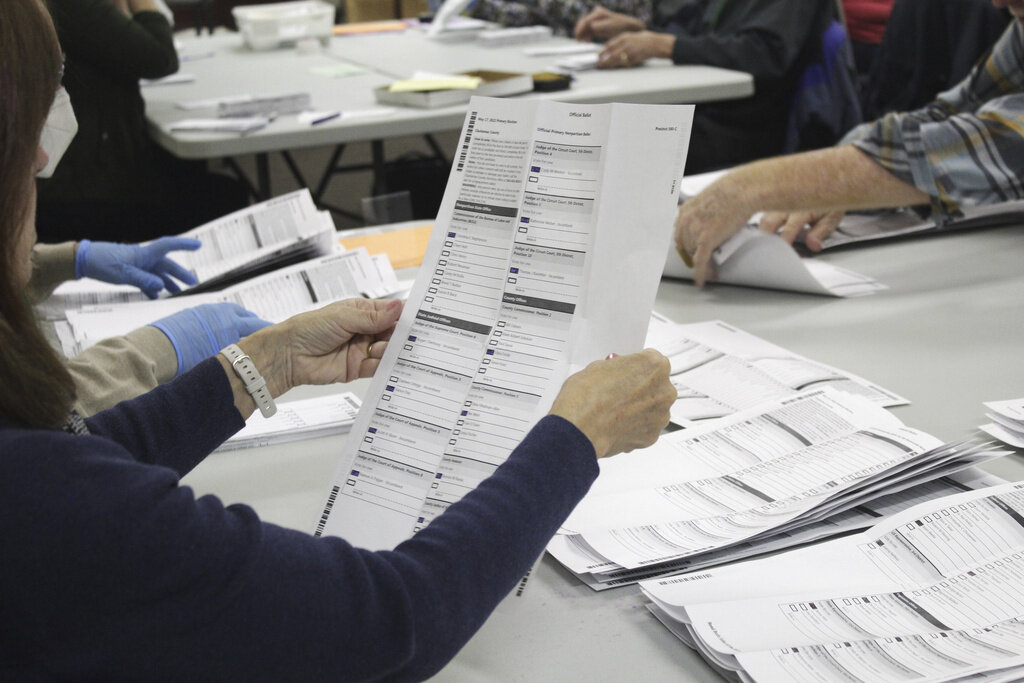 FILE - An election worker examines a ballot at the Clackamas County Elections office, May 19, 2022, in Oregon City, Ore. Problems with a ballot-sorting machine are delaying the vote count in a suburban Portland, Oregon county where issues with blurry bar codes on mail-in ballots delayed elections results in a key Congressional primary race for two weeks in 2022. (AP Photo/Gillian Flaccus, File)