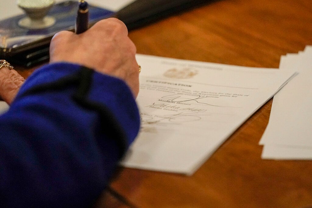 FILE - Members of Wisconsin's Electoral College cast their votes at the state Capitol in Madison, Wis., Monday, Dec. 14, 2020. (AP Photo/Morry Gash, Pool, File)